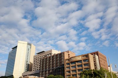 Low angle view of modern building against cloudy sky
