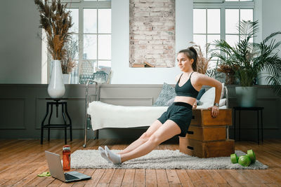 Positive athletic woman with neatly tied hair and tight sportswear shakes biceps, do push-ups 