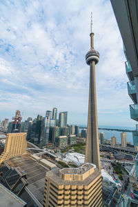 Aerial view of buildings in city against cloudy sky