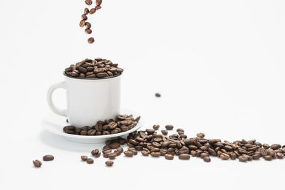 Coffee beans on table against white background