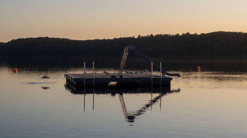 Sailboats moored in lake against clear sky