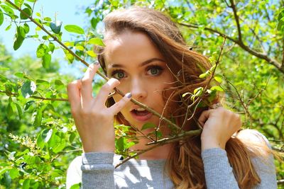 Portrait of young woman holding branch