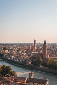 River amidst buildings in city against clear sky