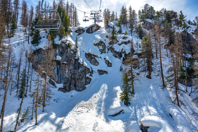 Snow covered land and trees against mountains