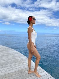 Full length of woman standing by sea against sky