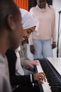 Smiling girl playing piano in recording studio