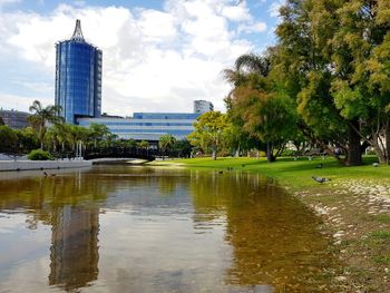 Scenic view of lake by buildings against sky