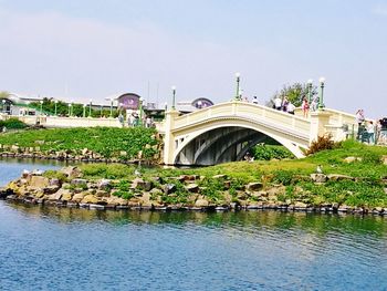 Arch bridge over river against sky