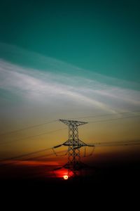 Low angle view of silhouette electricity pylon against sky during sunset