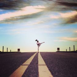 Woman practicing martial arts in sports uniform on the road