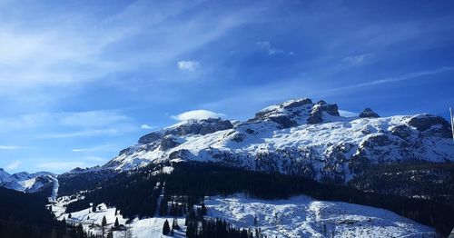 Scenic view of snowcapped mountains against blue sky