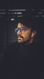 Close-up of man wearing sunglasses against black background