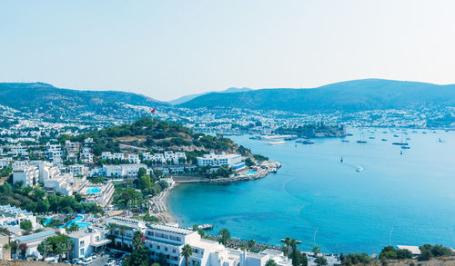 High angle view of city by sea against clear sky