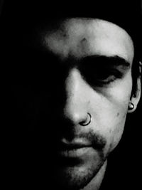 Close-up portrait of young man against black background