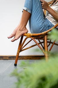 Woman sitting on wooden armchair on the balcony.