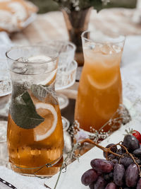 Close up of two orange lemonade drinks with some grapes in the right low corner