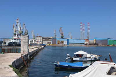 View of pier in city against clear blue sky
