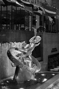 Midsection of woman with umbrella at night