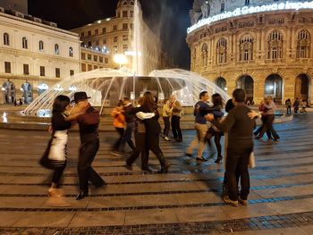 People dancing in illuminated city at night
