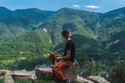 Woman sitting on mountain looking at mountains