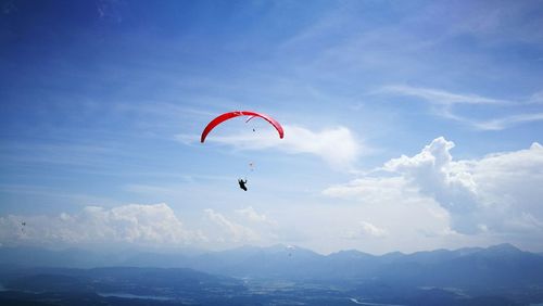 Low angle view of person paragliding against sky