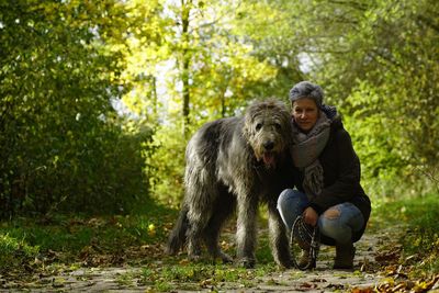 Portrait of woman with dog on field