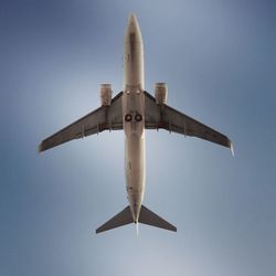 Low angle view of airplane against clear blue sky