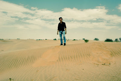 Full length of man standing on sand dune