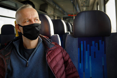Portrait of man wearing mask while sitting in car