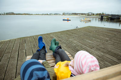 Brother an sister relaxing on chair by lake