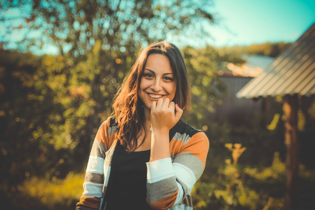 person, portrait, looking at camera, young adult, lifestyles, smiling, front view, casual clothing, focus on foreground, young women, leisure activity, happiness, standing, waist up, long hair, toothy smile