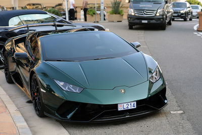 Close-up of cars parked on road in city