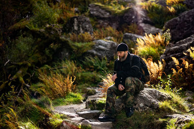 Young man sitting on rock