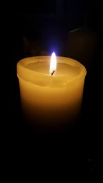 Close-up of illuminated candle against black background