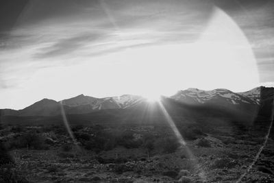 Sunlight streaming through mountains against bright sun