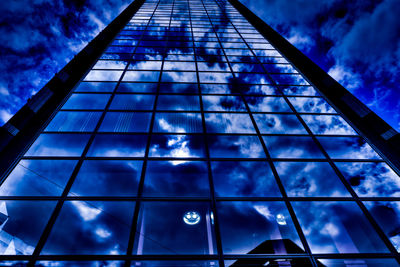 Low angle view of modern building against cloudy sky