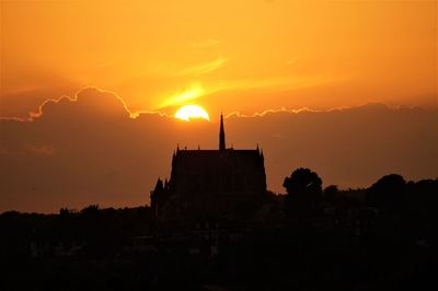 Silhouette of buildings against sky during sunset