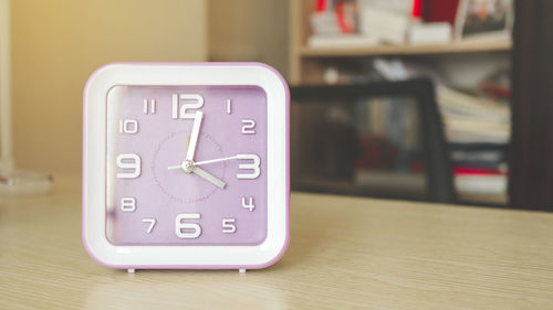 Close-up of clock on table at home