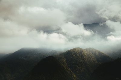 Scenic view of mountains against cloudy sky