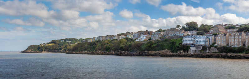 Panoramic view of buildings by sea against sky