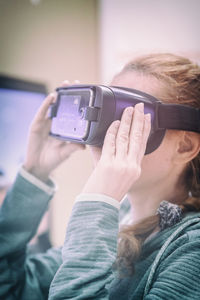 Mid adult woman using virtual reality at home