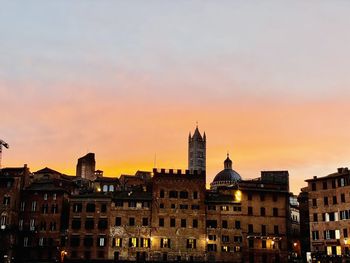 Buildings in city during sunset