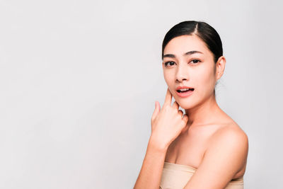 Portrait of beautiful young woman against white background