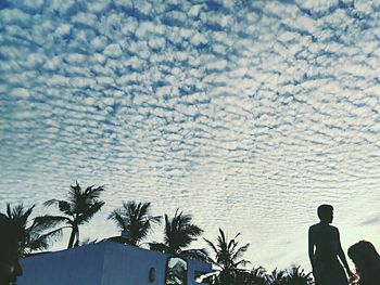 Silhouette of people against cloudy sky