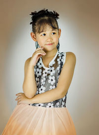 Portrait of a smiling young woman against gray background