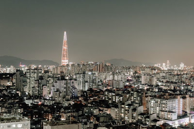 Illuminated buildings in city against sky at night