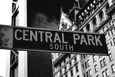 Low angle view of sign board against sky in city