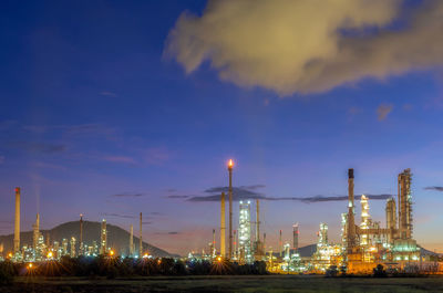 Illuminated factory against sky at night oil refinery
