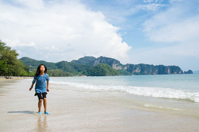 Full length of young woman standing on beach