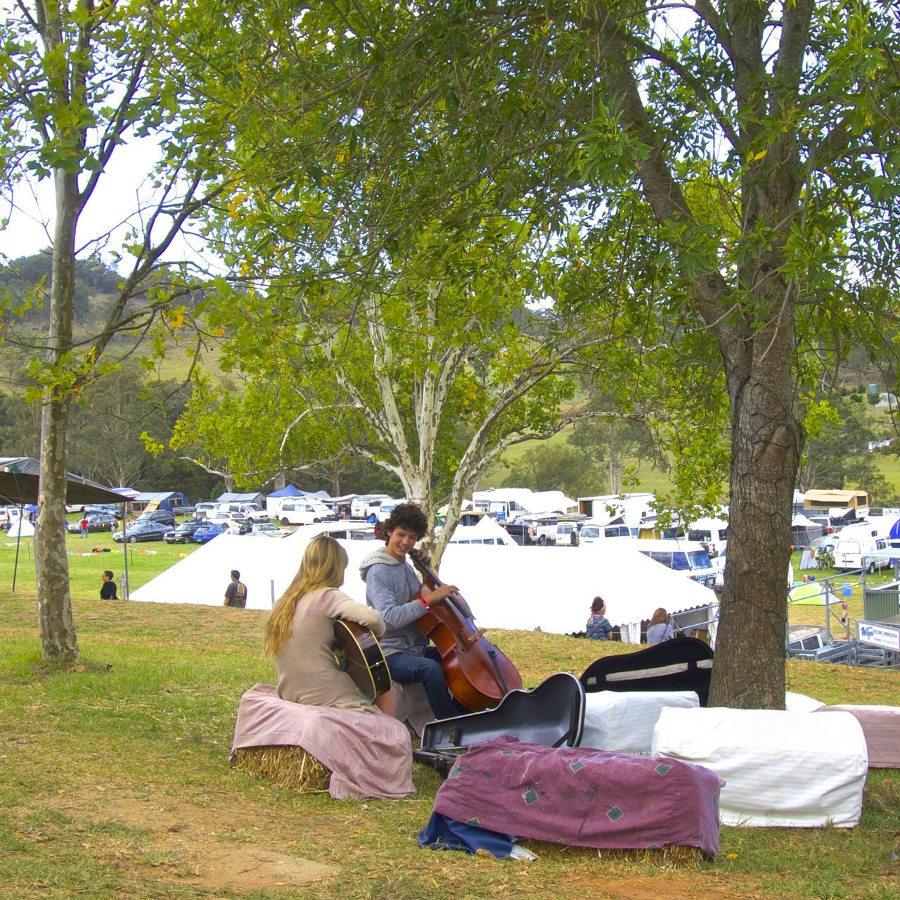 sitting, music, tree, relaxation, togetherness, young adult, women, young women, arts culture and entertainment, full length, vacations, adults only, summer, adult, people, leisure activity, outdoors, musical instrument, guitar, playing, men, friendship, picnic, plucking an instrument, day, beauty in nature, nature, musician